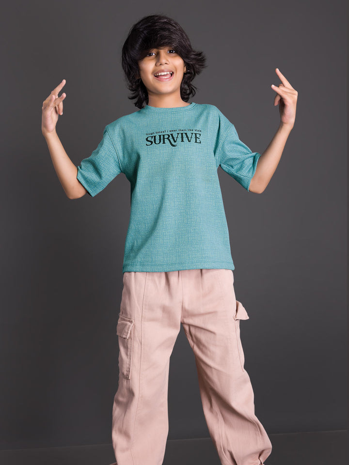 Boy wearing a printed drop shoulder round neck t-shirt with a relaxed fit