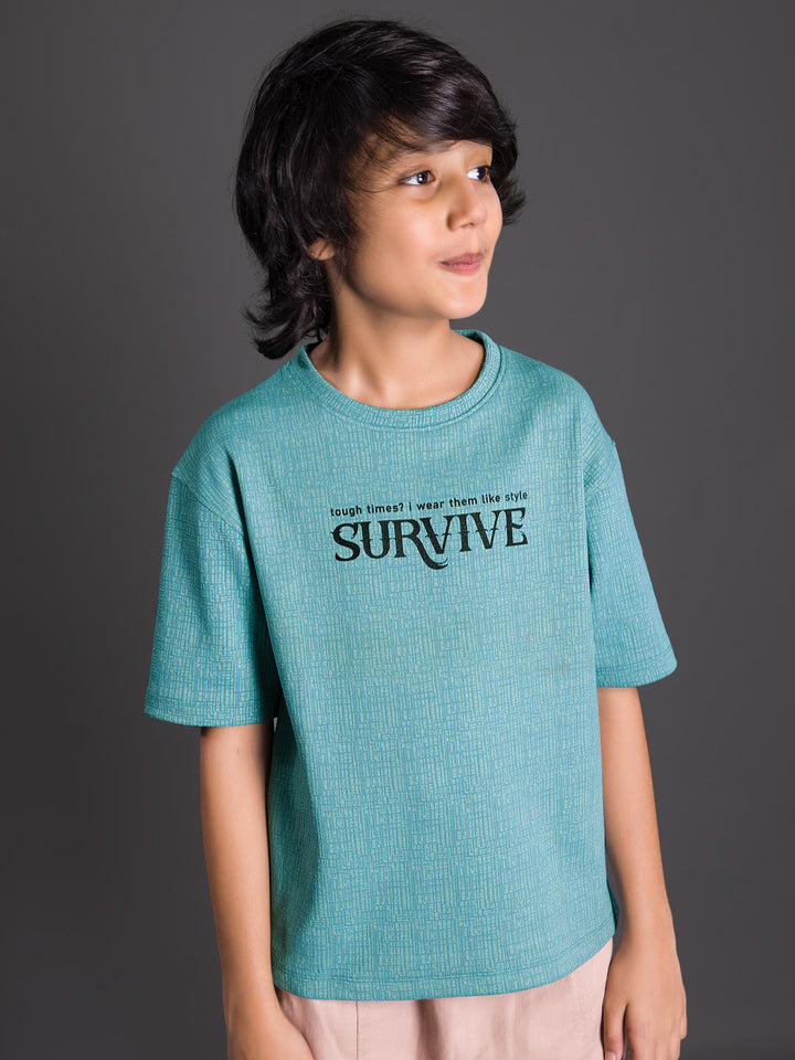 Boy wearing a printed drop shoulder round neck t-shirt with a relaxed fit