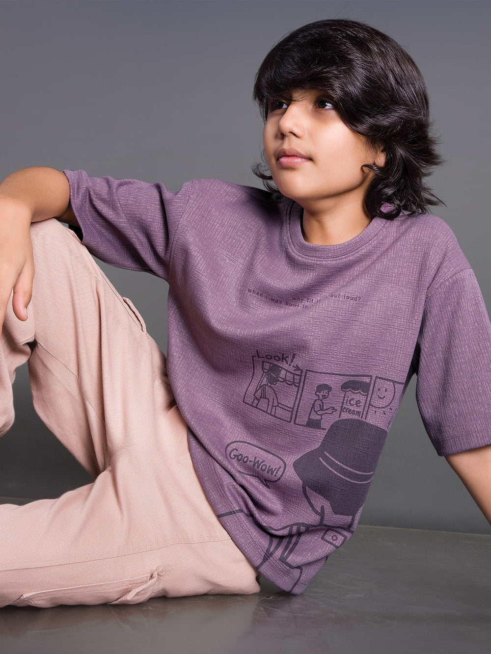 Boy wearing a printed drop shoulder round neck t-shirt with a relaxed fit