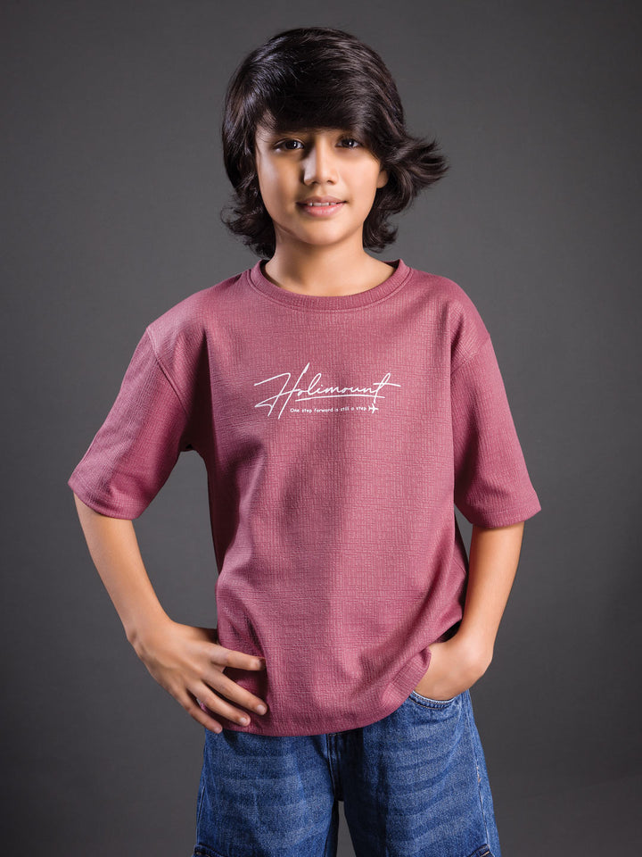 Boy wearing a printed drop shoulder round neck t-shirt with a relaxed fit