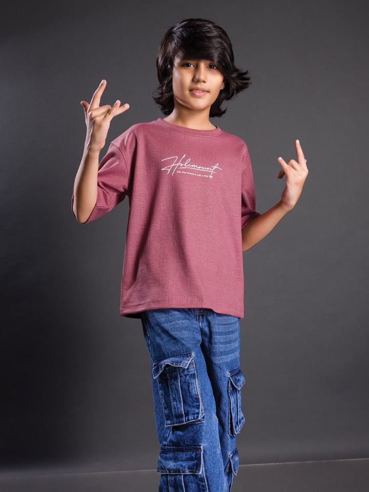 Boy wearing a printed drop shoulder round neck t-shirt with a relaxed fit