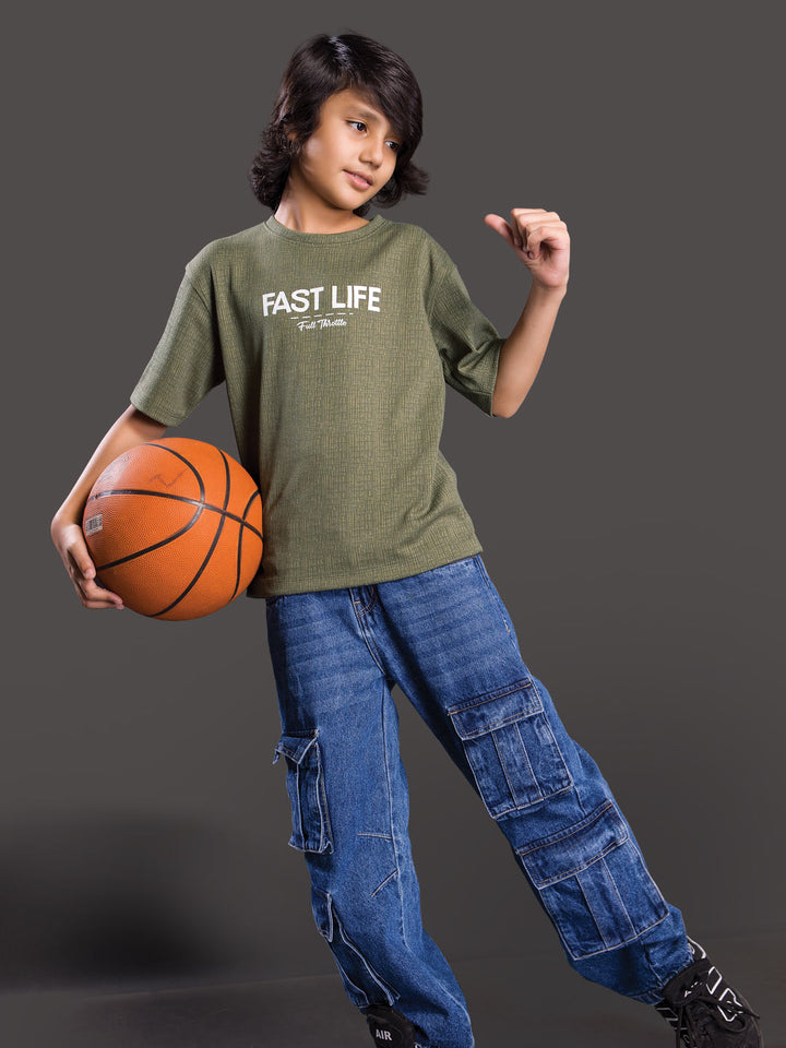 Boy wearing a printed drop shoulder round neck t-shirt with a relaxed fit