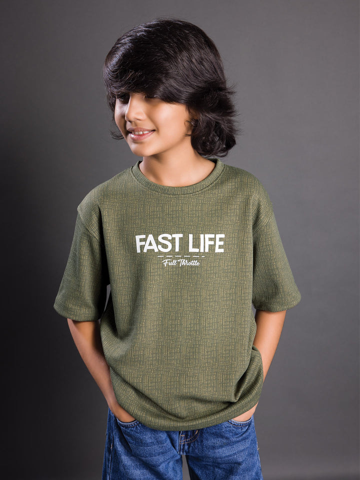 Boy wearing a printed drop shoulder round neck t-shirt with a relaxed fit