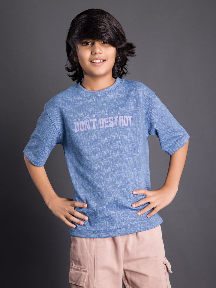 Boy wearing a printed drop shoulder round neck t-shirt with a relaxed fit