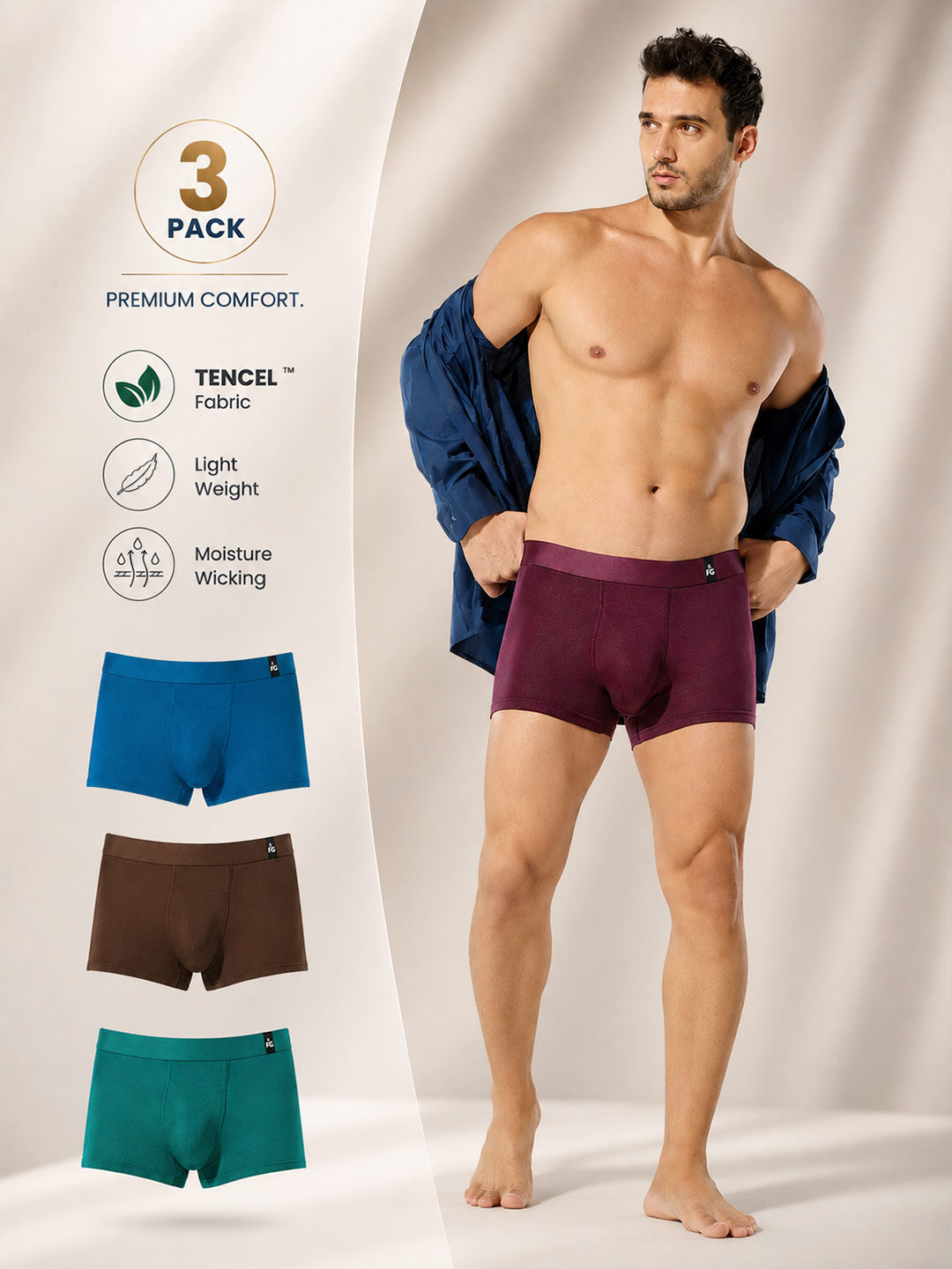 A male model stands in a studio wearing a pair of plum boxer briefs, with his navy jacket off his shoulders. On the left, a vertical panel shows a '3 PACK' badge, product features with TENCEL fabric icons, and three additional color options: blue, brown, and teal.