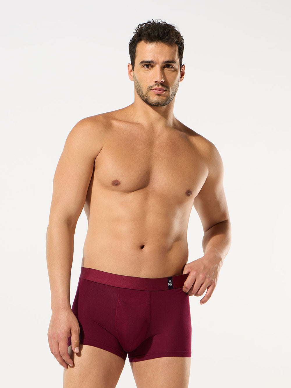 Man wearing maroon underwear on a white background