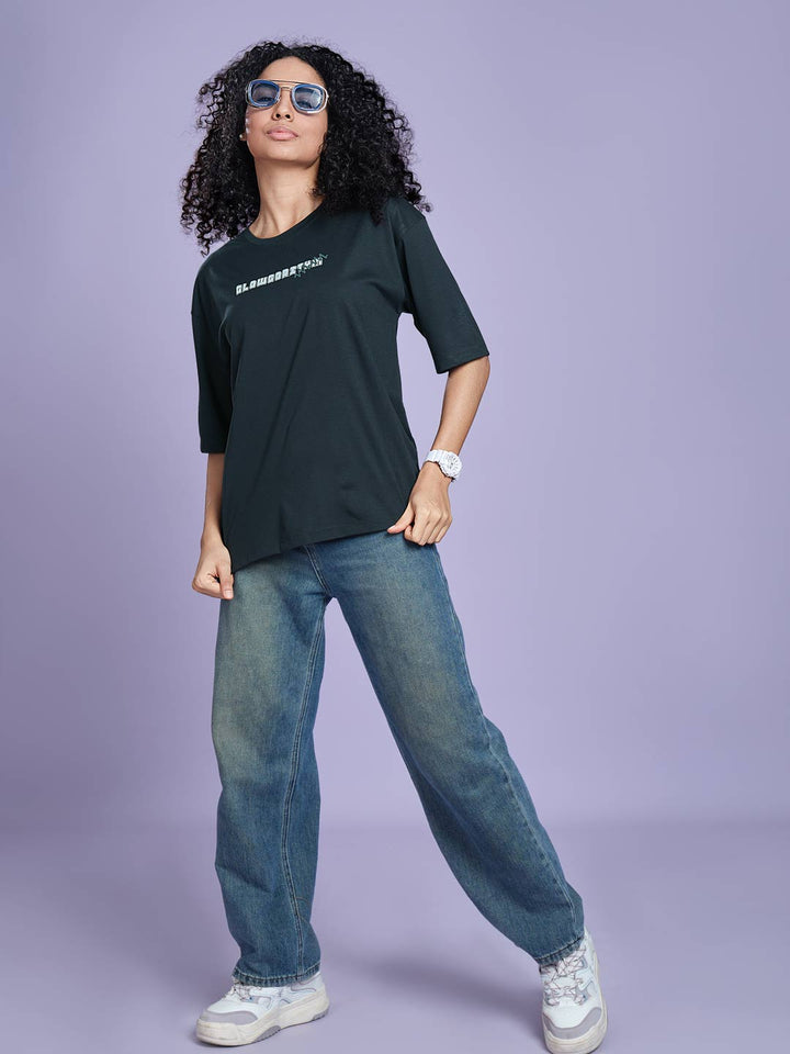 Person wearing a black t-shirt with text, blue jeans, and sunglasses on a purple background