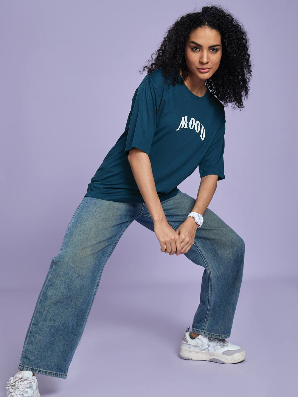 Person wearing a blue 'Mood' t-shirt and jeans on a purple background