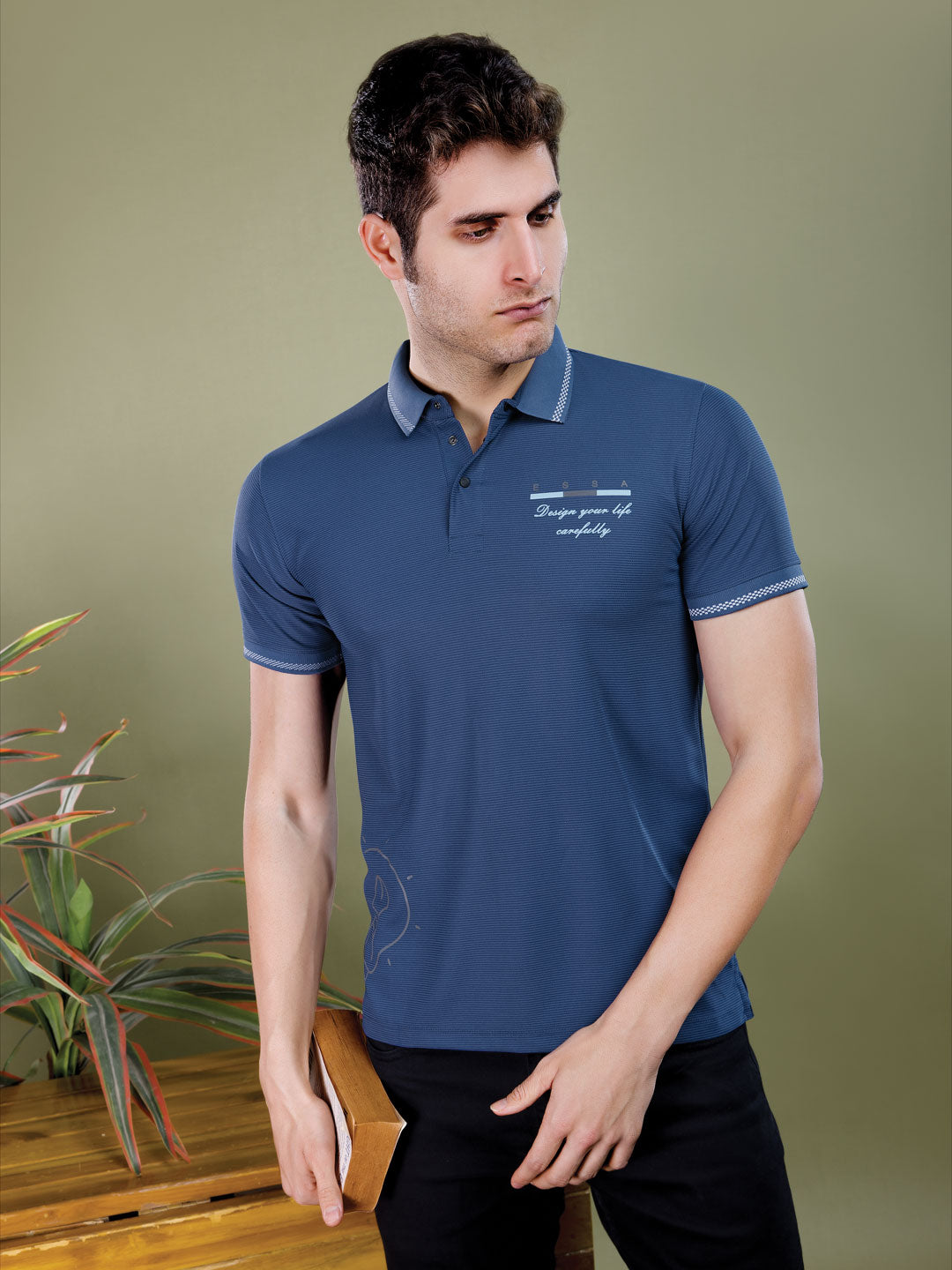 Man wearing a blue polo shirt with text on a green background