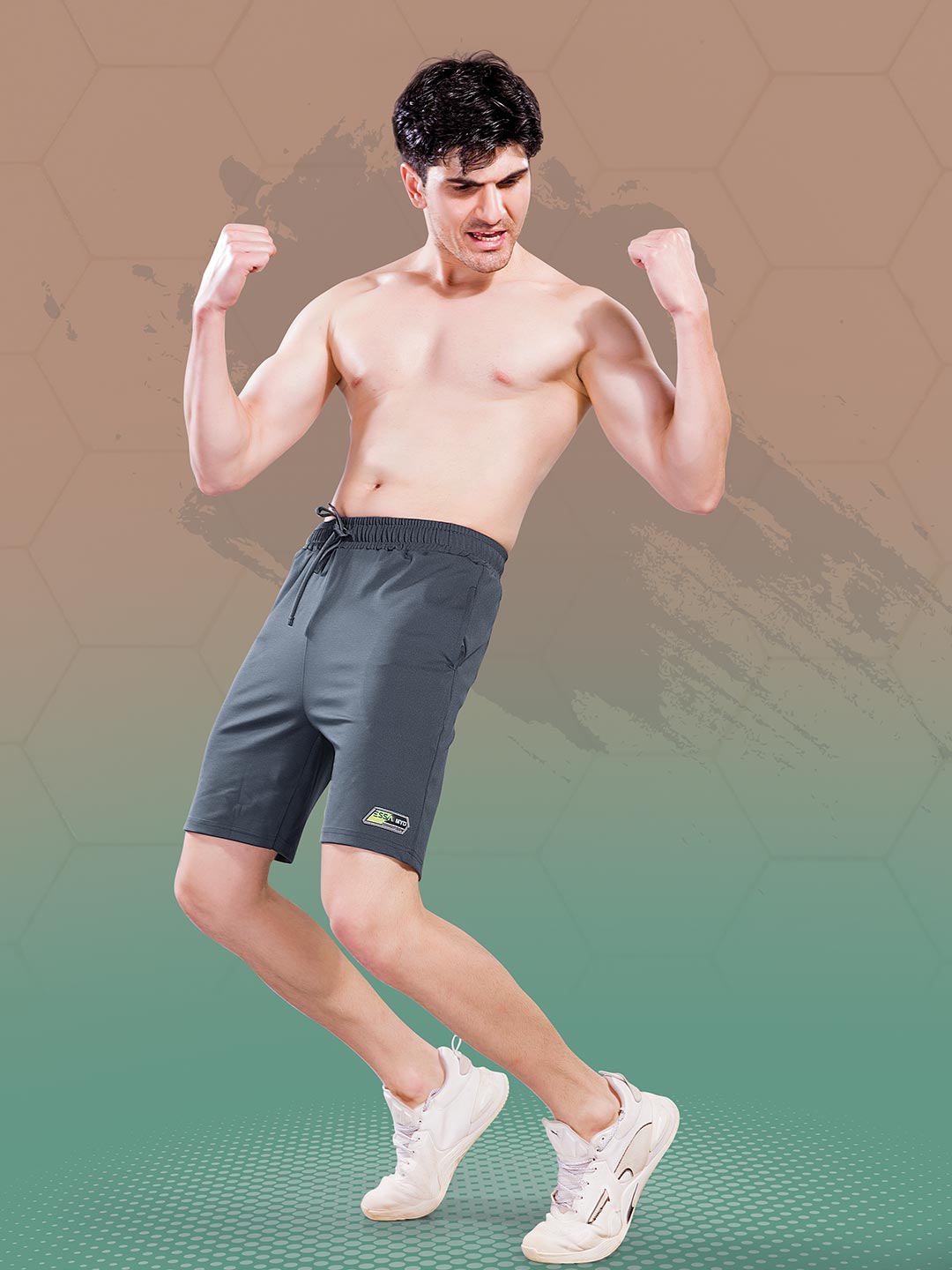 Man flexing muscles wearing dark shorts on a gradient background