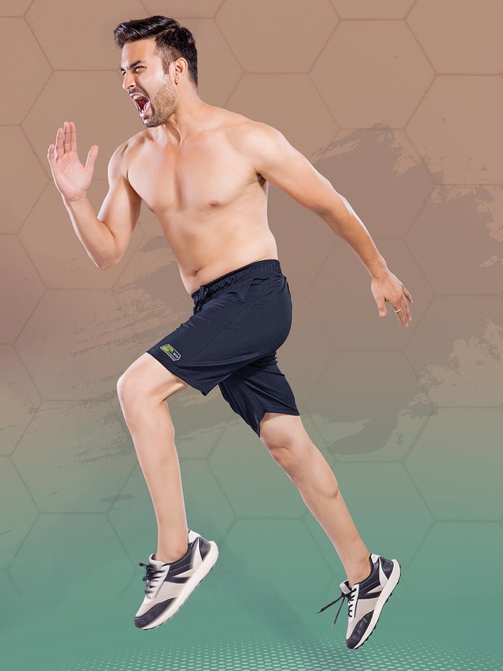 Man in black athletic shorts jumping in front of a gradient background