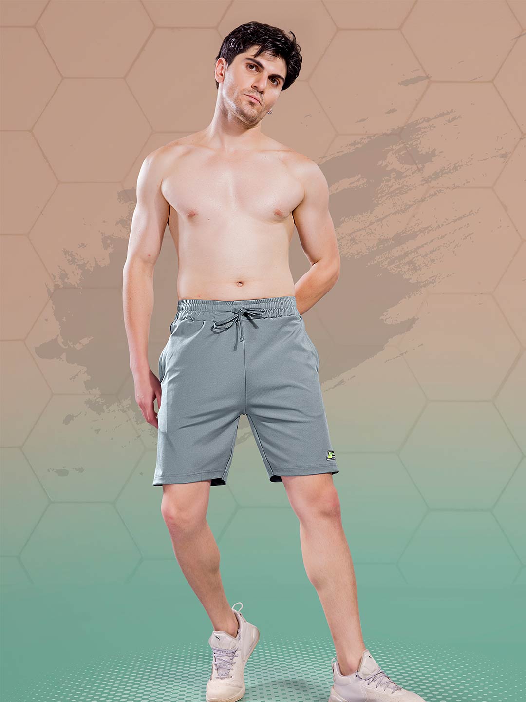 Man wearing gray shorts on a gradient background