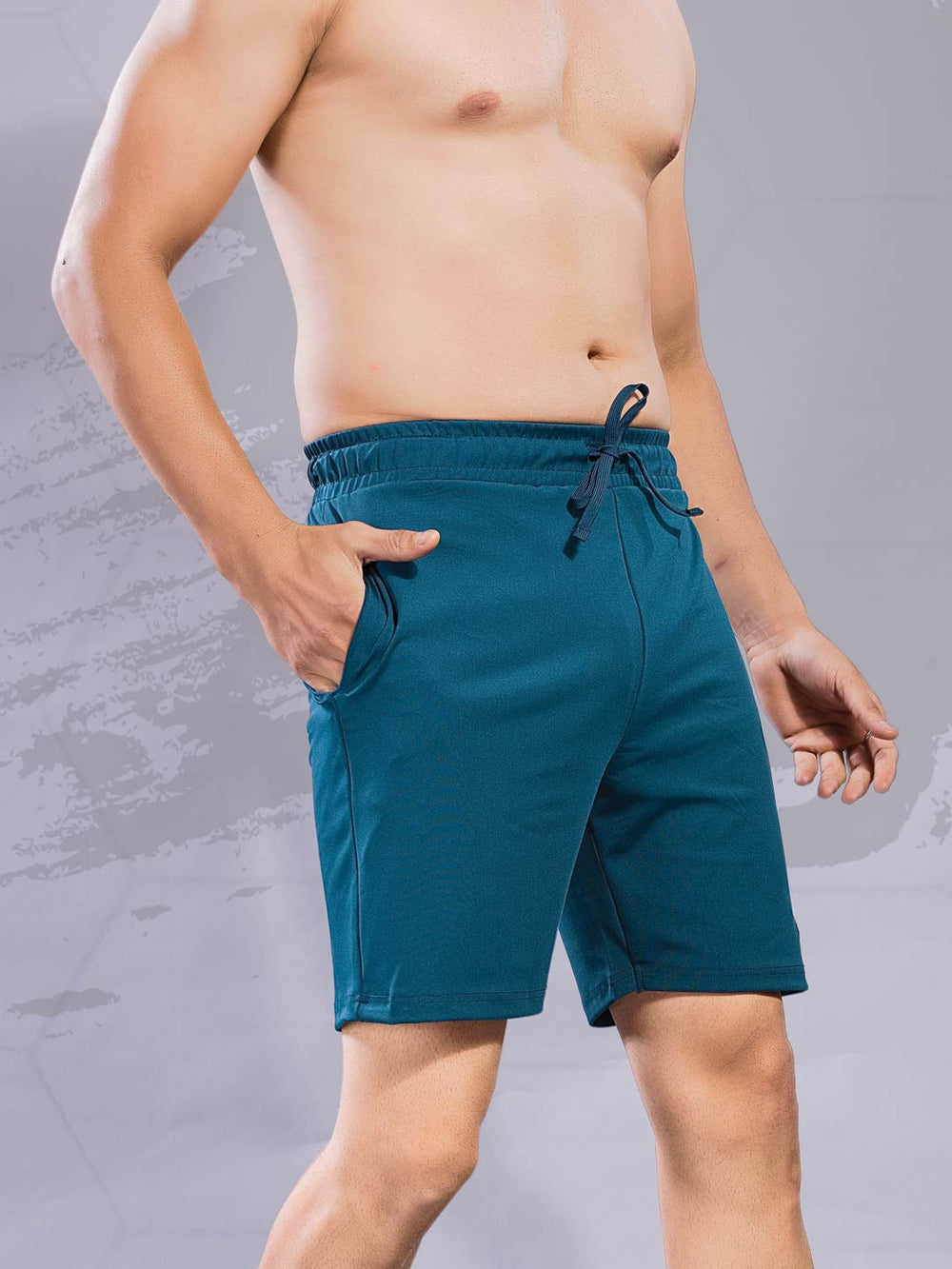 Teal shorts worn by a person on a gray background