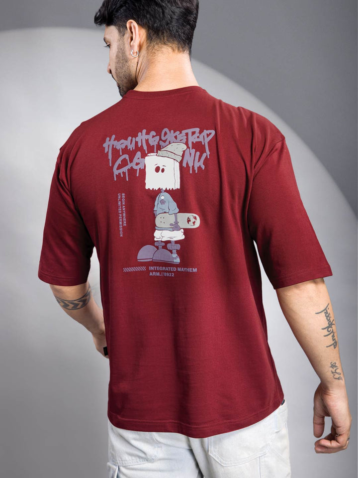 Man wearing a maroon t-shirt with graphic design on the back against a gray background