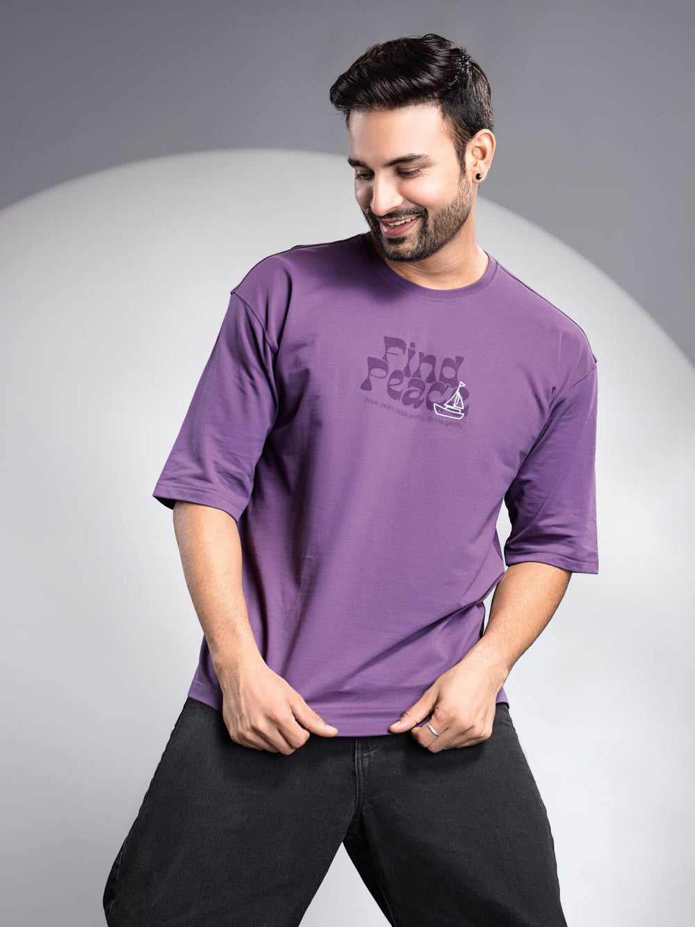 Man wearing a purple t-shirt with text and logo on a gray background