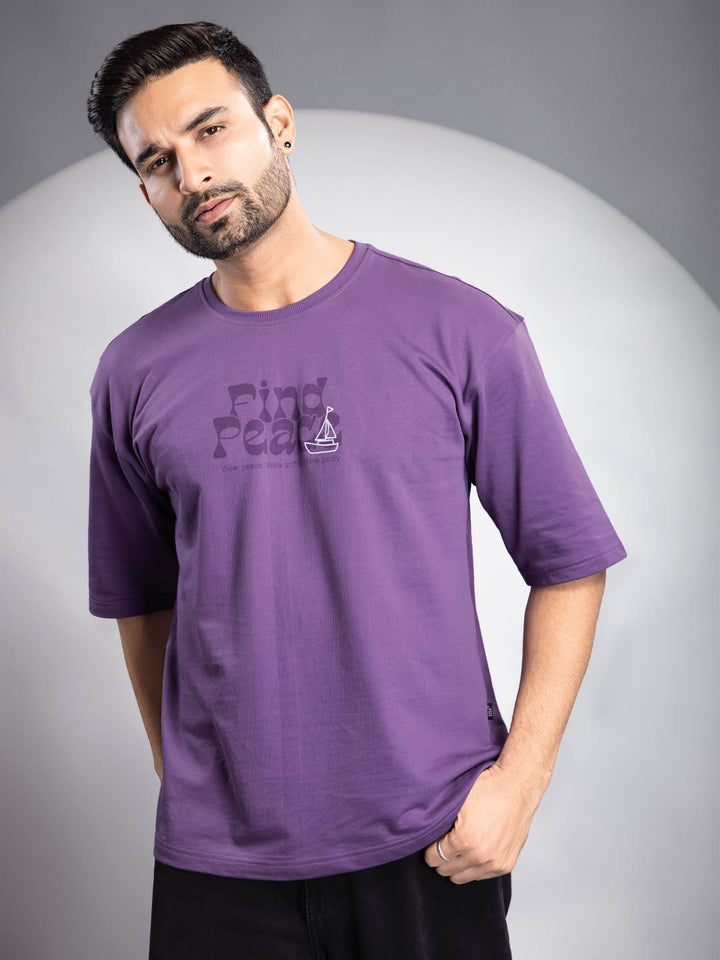 Man wearing a purple t-shirt with text on a gray background