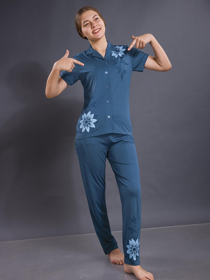 Woman wearing a blue pajama set with floral designs on a gray background