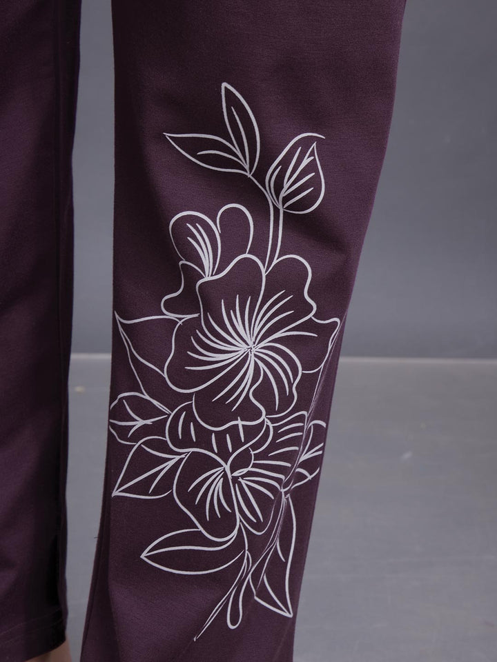 Purple pants with white floral embroidery on a gray background