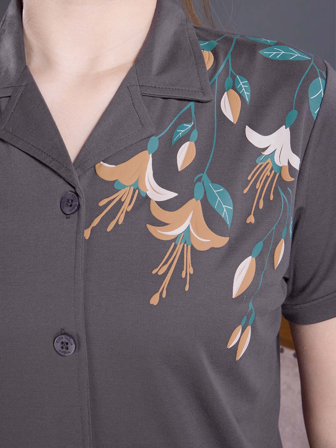 Dark gray shirt with floral pattern on a plain background