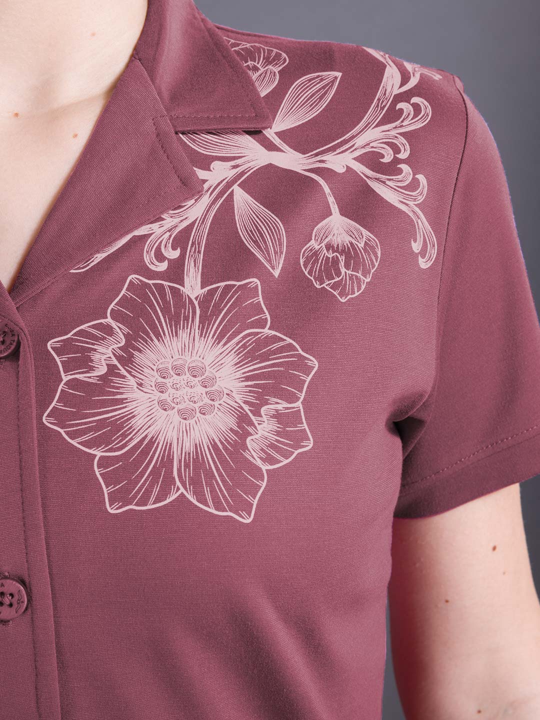Maroon shirt with white floral design on a gray background