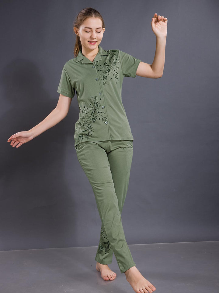 Woman wearing a green pajama set against a gray background