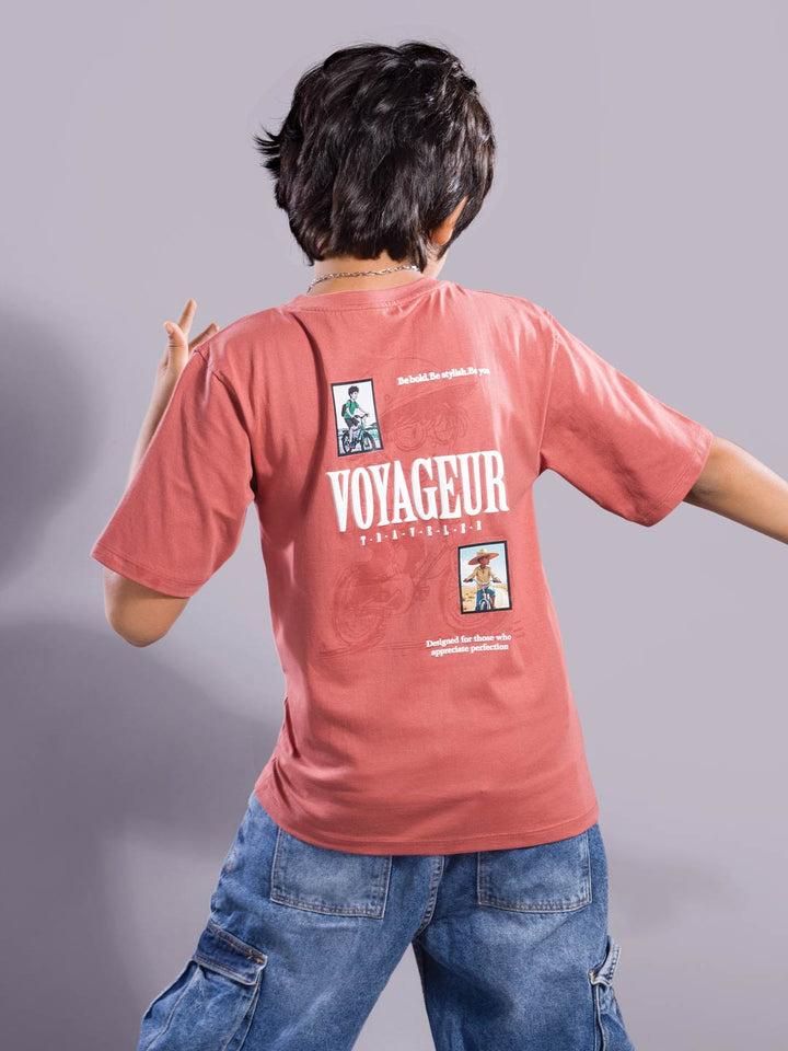 Person wearing a light red 'Voyageur' t-shirt with graphics on the back against a gray background