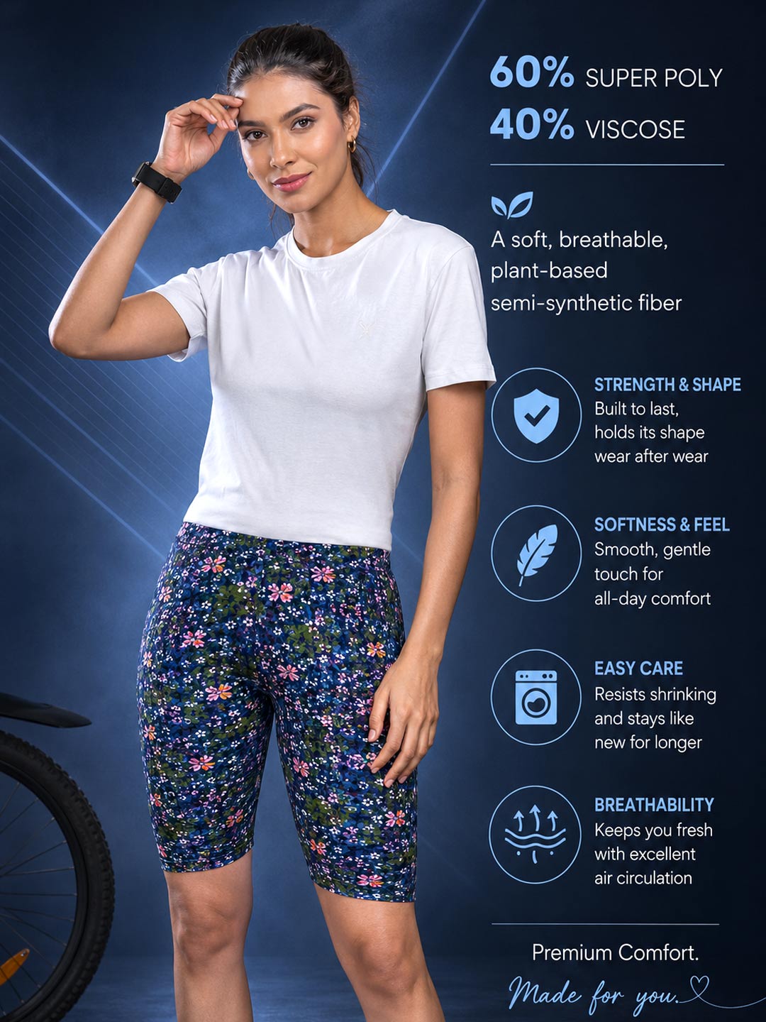 A woman modeling floral athletic shorts and a white t-shirt against a dark blue promotional background with product text and feature icons. The shorts have a navy base with pink, purple, and green floral pattern.
