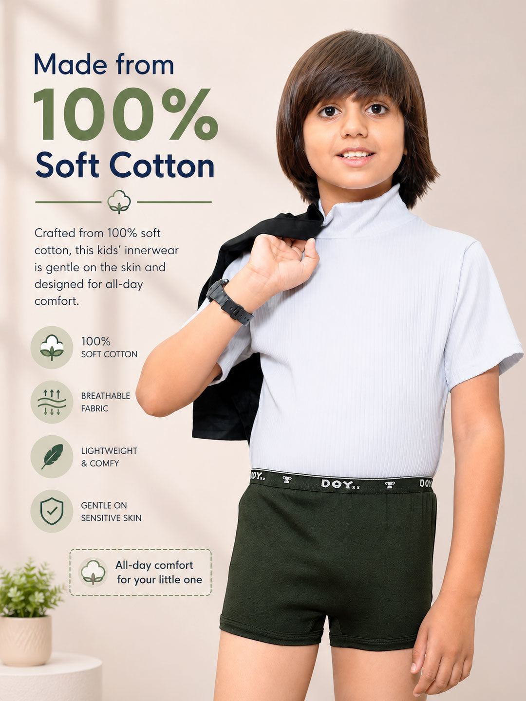 A child model wearing a light blue short-sleeve kids' inner shirt and dark green shorts, with promotional text on the left highlighting 100% soft cotton fabric. #color_heavy-metal