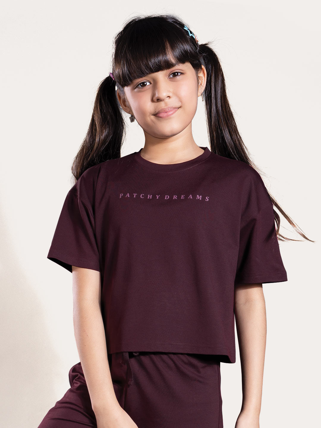 Person wearing a maroon outfit with text on a plain background