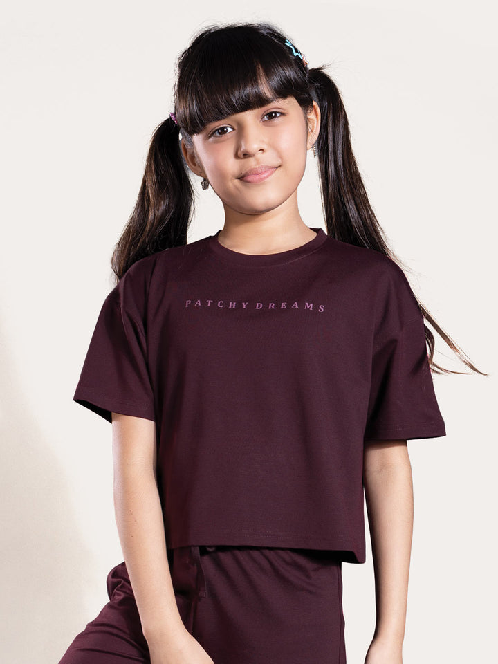 Person wearing a maroon outfit with text on a plain background