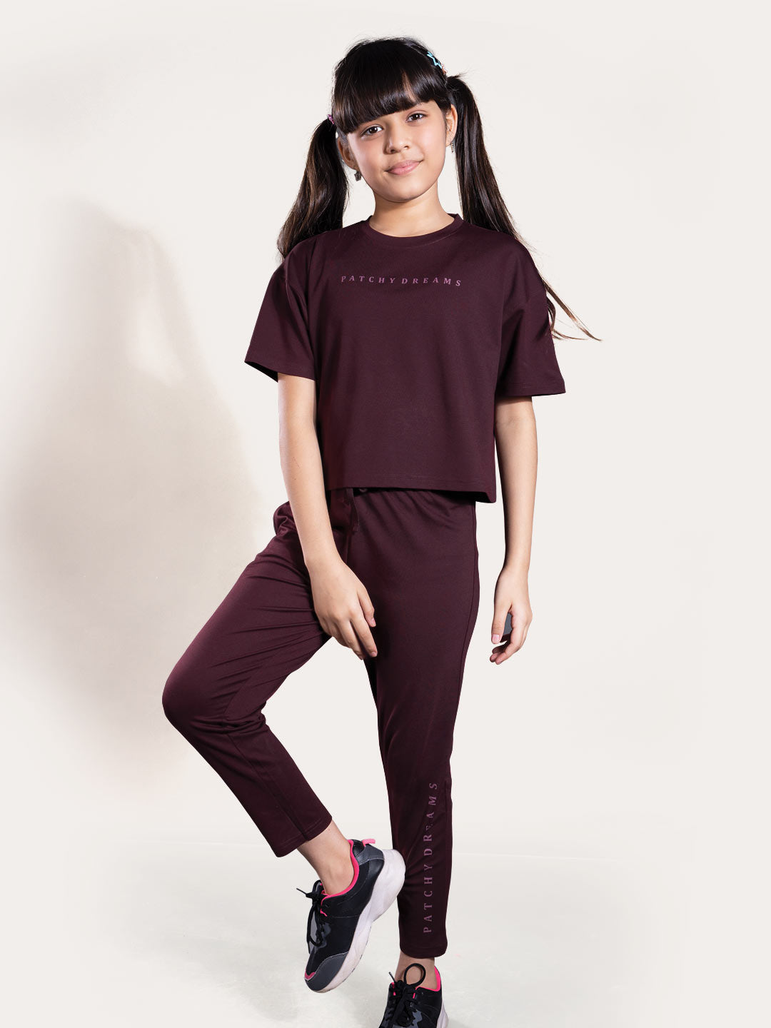 Person wearing a maroon outfit with text on a plain background