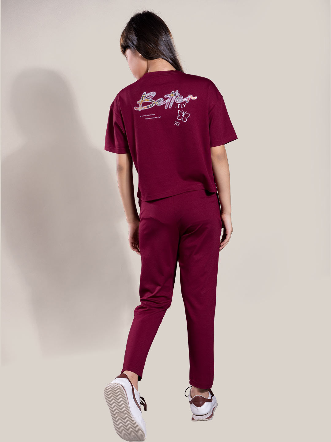 Person wearing a maroon outfit with 'Better fly' branding on a plain background