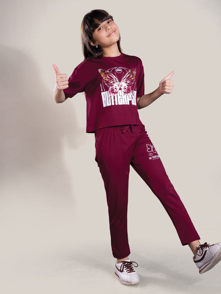 Child wearing a maroon tracksuit with visible branding on a plain background