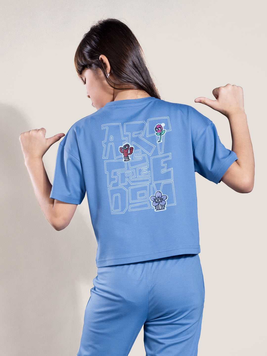 Person wearing a blue outfit with graphics on the back against a plain background