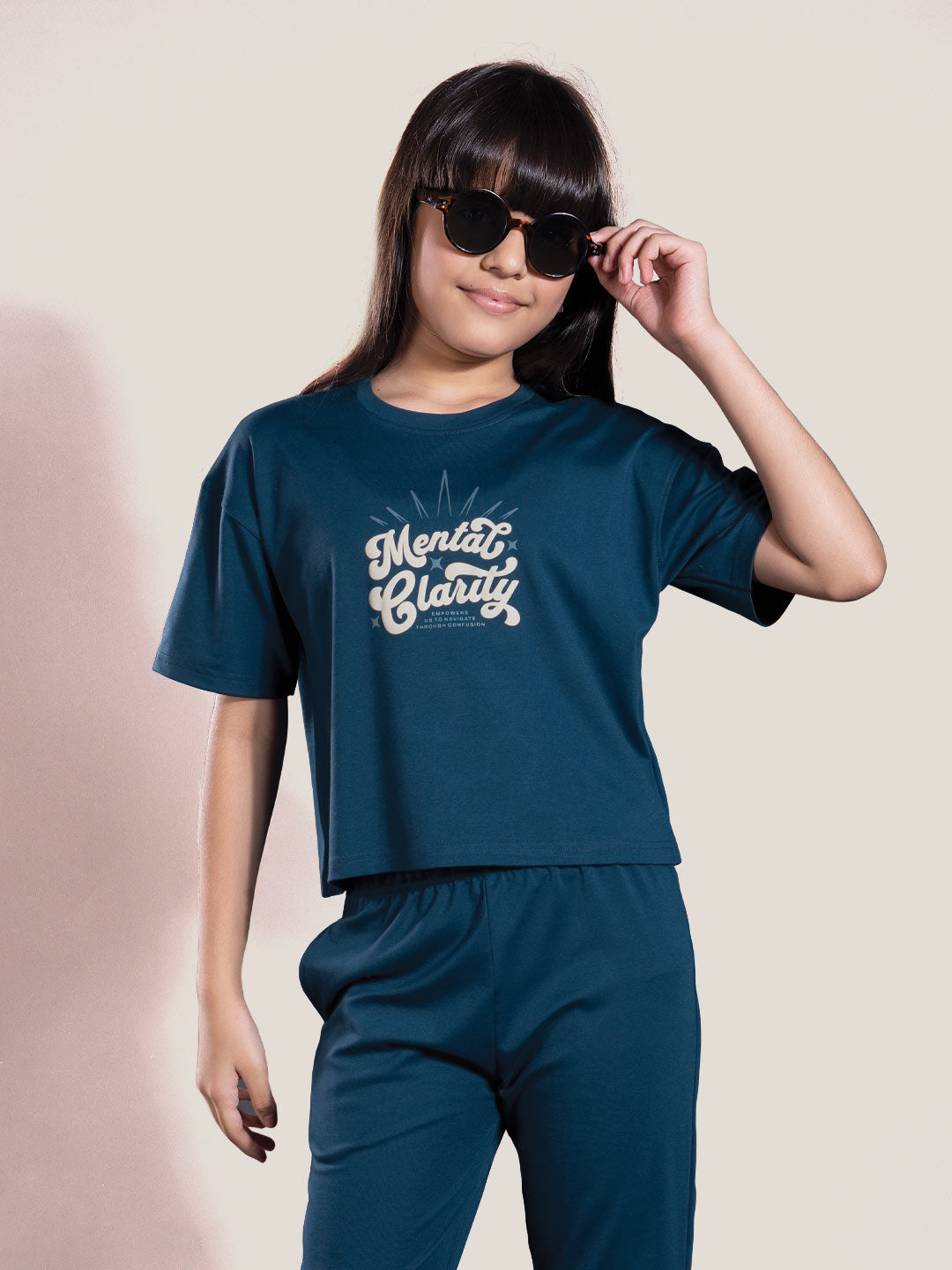 Person wearing a teal outfit with 'Mental Clarity' text on a plain background