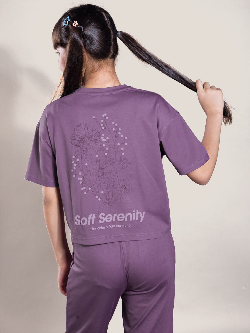 Person wearing a purple 'Soft Serenity' outfit with floral design on a plain background