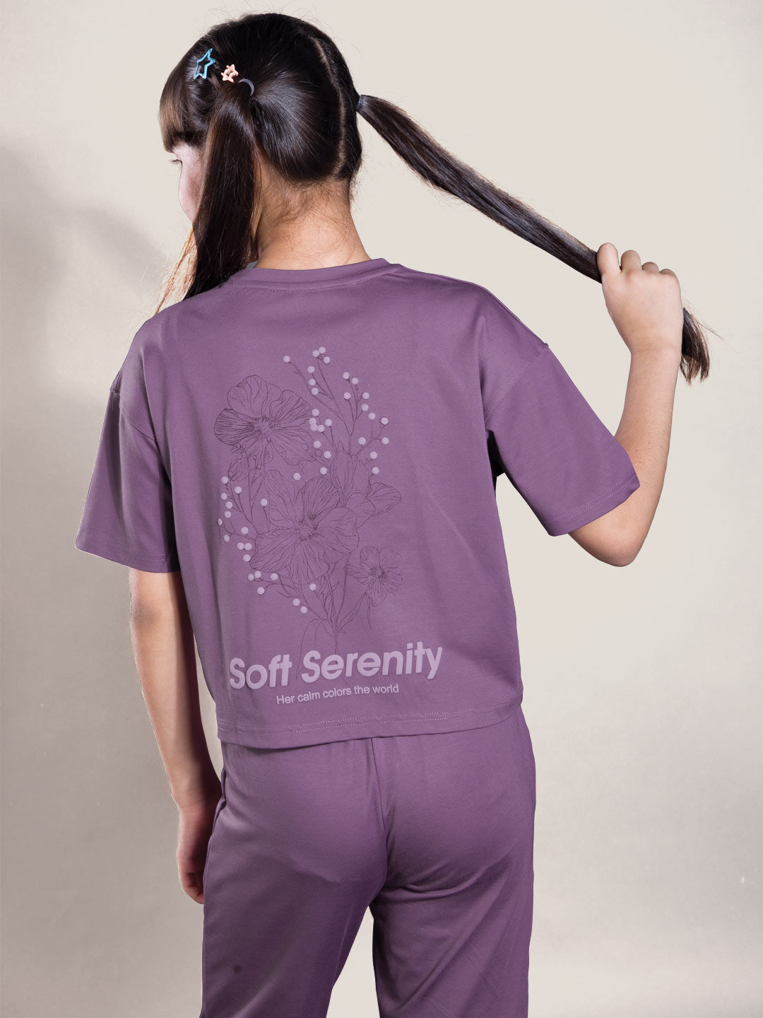 Person wearing a purple 'Soft Serenity' outfit with floral design on a plain background