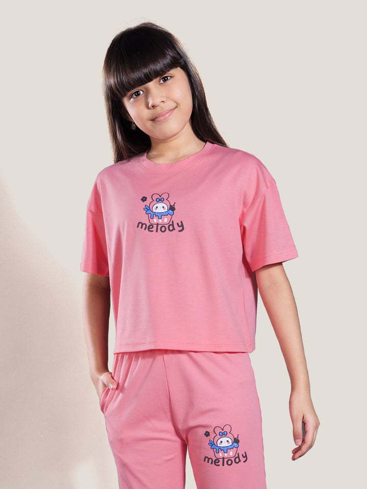 Young girl wearing a pink outfit with 'melody' branding on a plain background