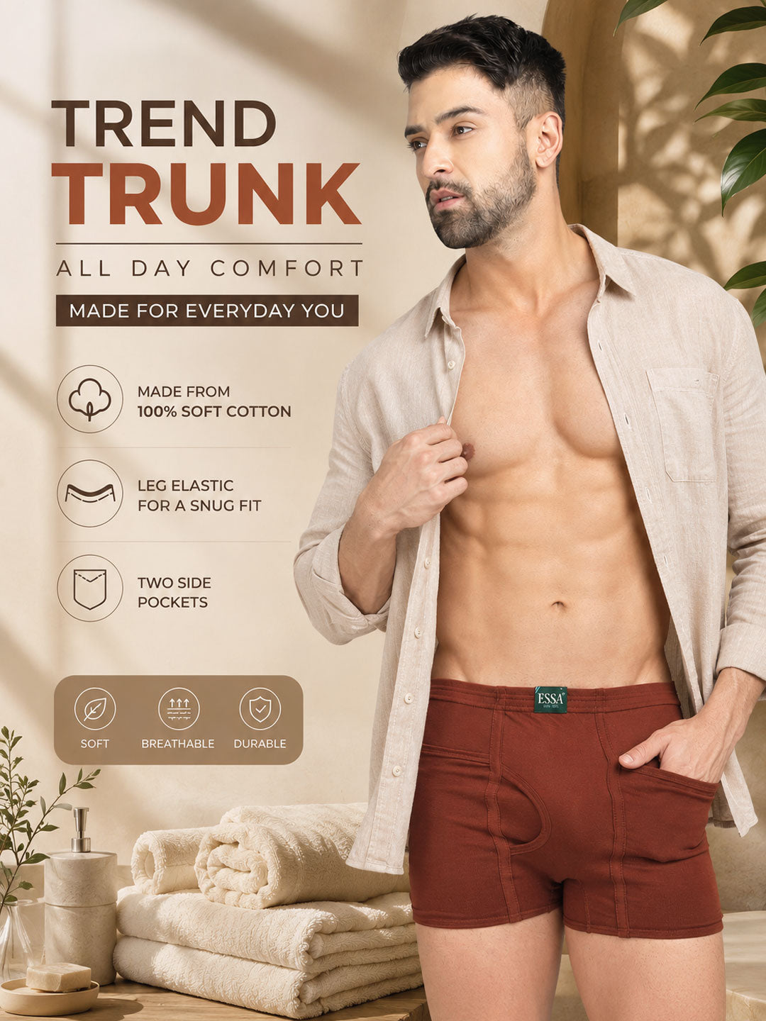 A man wearing brown elastic waist boxer briefs with side pockets, styled with an open beige shirt in a warm, sunlit bathroom setting. The image features promotional text highlighting the product's comfort, cotton quality, leg elasticity, and side pockets. #color_cumin